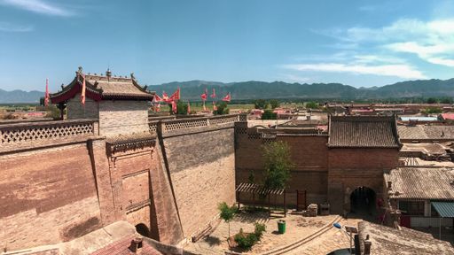 A scenic view of Hwaseong Fortress in South Korea with a background of mountains on a sunny day
