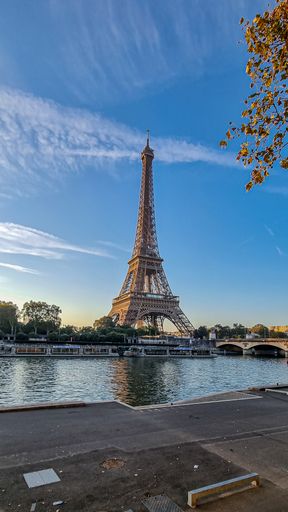 A vertical shot of the Seine river in the background of the Eiffel Tower.