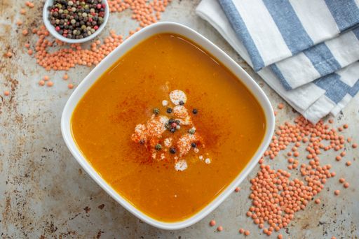 A top view of a lentil soup made with veggies in a white bowl