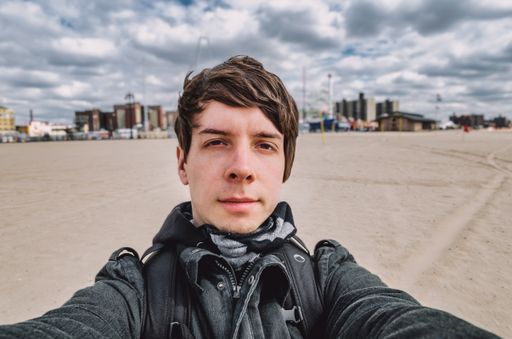 A young German male taking a selfie in front of Coney island in  Brooklyn, NY, USA