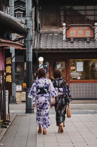 A vertical shot of two fashionable Japanese women walking in the street