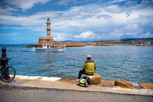 A distant view of the lighthouse of Chania and the sea on the foreground in Crete, Greece