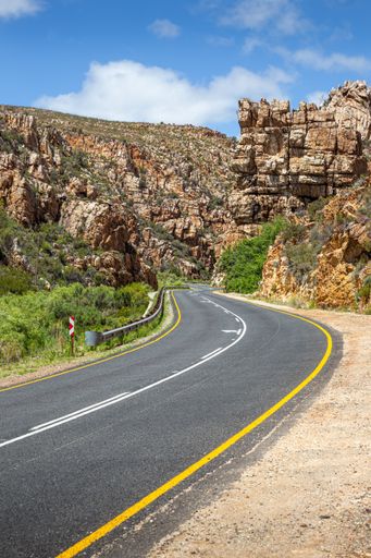 The scenic R339 rural road, known as Prince Alfred Pass, winds through a narrow canyon near Uniondale in Western Cape, South Africa.