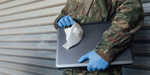 A man with a medical mask and gloves working on a tablet during Coronavirus pandemic