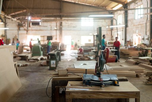 A close shot of a wood cutting machine in the factory with a blurred background