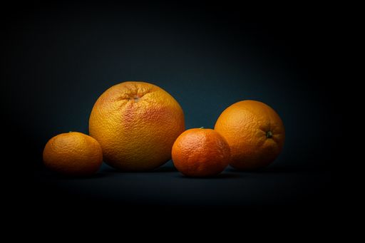A close-up shot of citruses in the dark background.