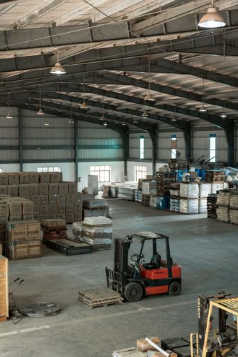 A vertical shot of a forklift in a warehouse