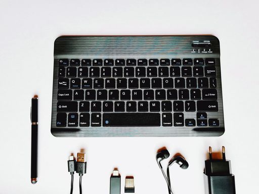 A top view of a white office desk with a keyboard and other equipment on it