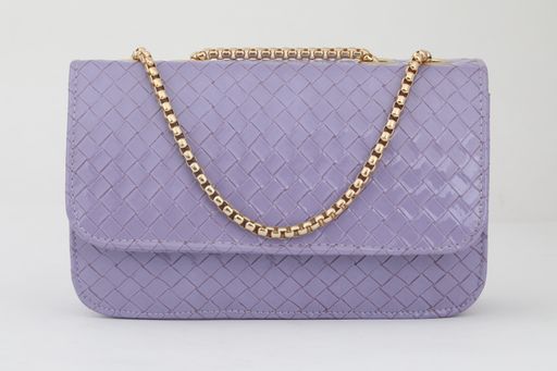 A closeup shot of a fashionable purple leather bag with a golden chain isolated on the white background