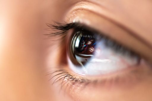 A closeup shot of a brown human eye under the lights