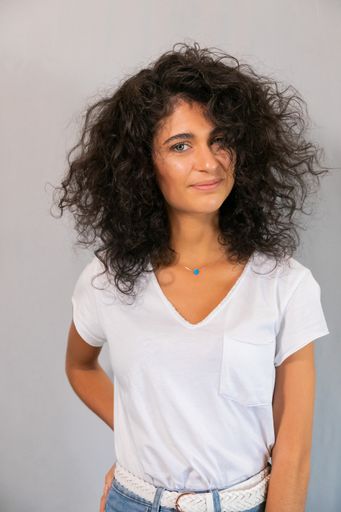 A vertical shot of a female hair model on set in a salon