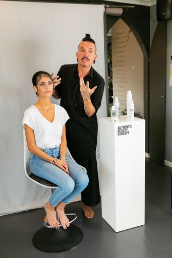 A vertical shot of Celebrity hairstylist Reto Camichael in salon with female model