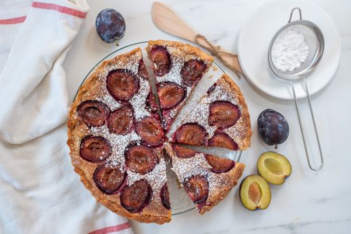 A top view of a delicious pie baked with plums in a kitchen