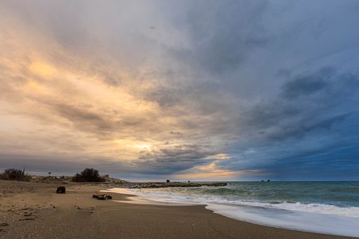 A beautiful shot of a seascape under the cloudy skies during sunrise
