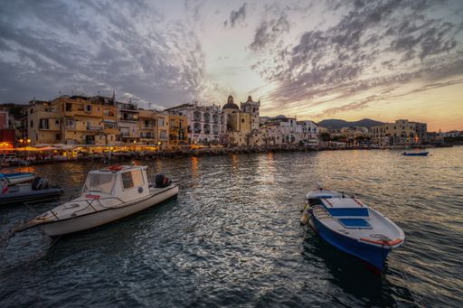 Fishing boats moored at the colorful Ischia Ponte marina at sunset. Ischia, Campania, Italy, Sept. 2021