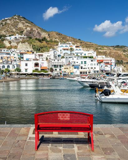 Red bench facing the port of SantAngelo, Ischia, Italy