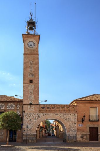 Consuegra, Toldeo, Spain. Gate and bell tower, parts of the town hall on Plaza Espana, in late afternoon