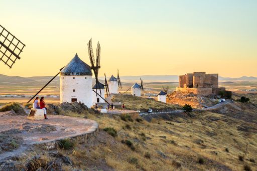 Traditional Spanish windmills and a medieval castle near the village of Consuegra, Toiedo, Spain.