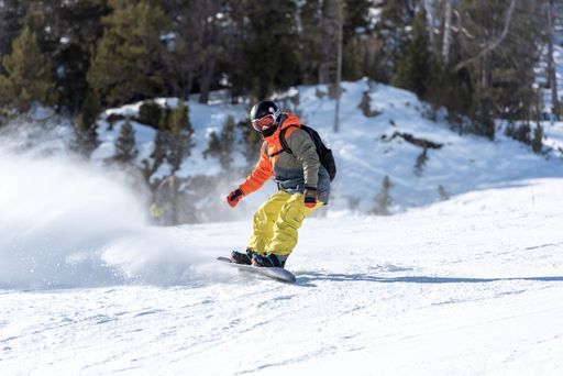 A man skating snowboard with a split board going down the mountains of the Pyrenees in Andorra