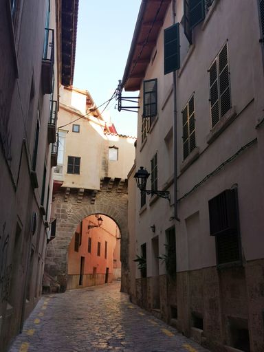 A narrow street surrounded by buildings in Palma de Mallorca, Balearic Islands, Spain
