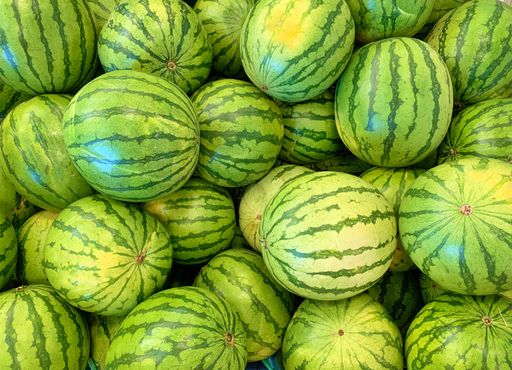 A top view of a stack of fresh and organic watermelons in the market