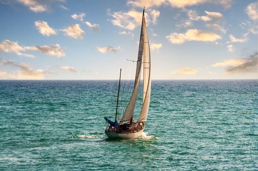 Sailing boat with full sail on the ocean with a beautiful sky. High quality photo