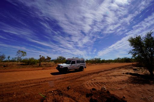 A traveling by car on the Gibb River Road with cloudy sky on the background