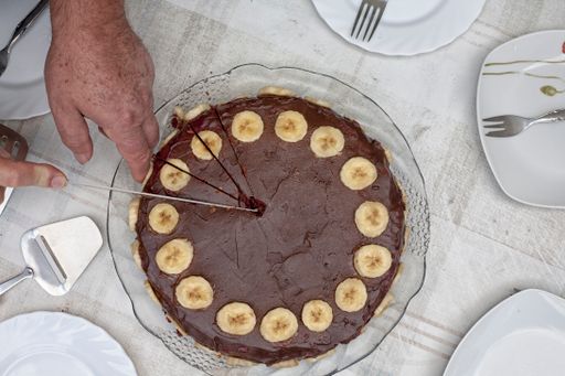 A top view shot of a chocolate cake with slices of bananas along the edges