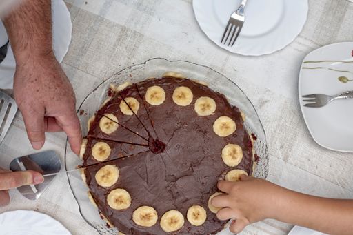 A top view shot of a chocolate cake with slices of bananas along the edges