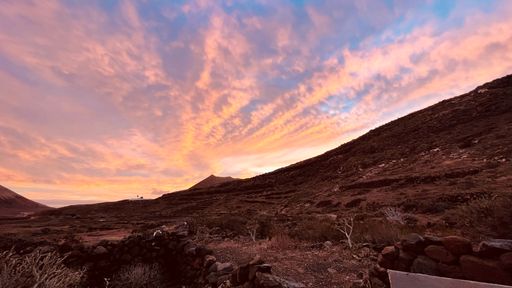 A landscape of abandoned stone building in the field during a breathtaking sunset
