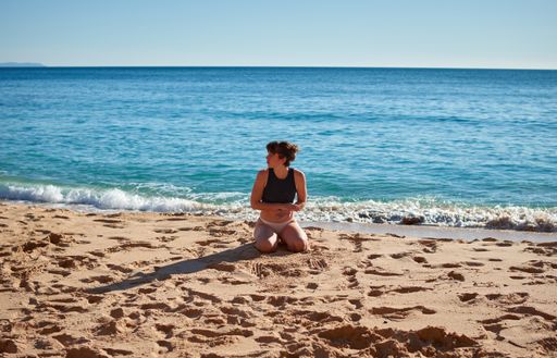 A closeup of a girl doing a yoga on the beach