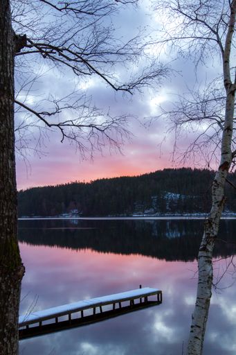 A vertical shot of a lake reflecting the mountain during sunset in winter