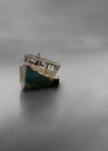 An abandoned boat in the medway river under the cloudy skies
