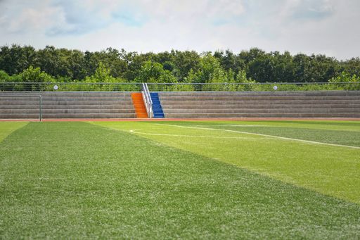 A green football field with concrete seats