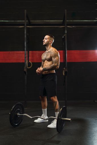 A tattooed athlete working out in the gym