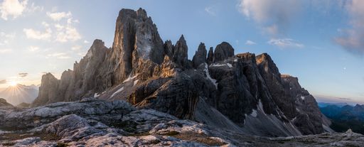 A panoramic shot of mountains with a blue sky in the background at daytime