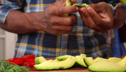 An African-American man's hands peeling an avocado
