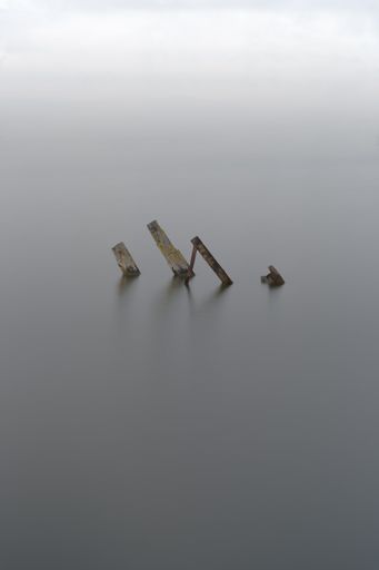 A vertical shot of a machinery in a sea on a foggy day