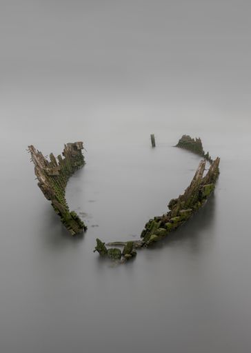An abandoned shipwreck in the medway river under the cloudy skies