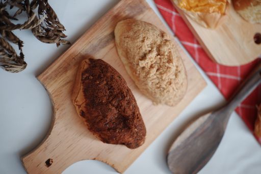 A closeup shot of delicious goods on a wooden cooking tray at a bakery