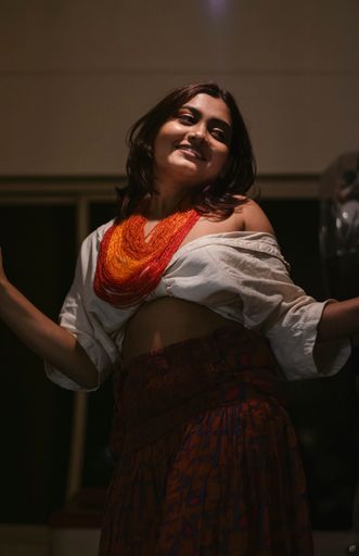 A vertical shot of an Indian woman smiling and dancing