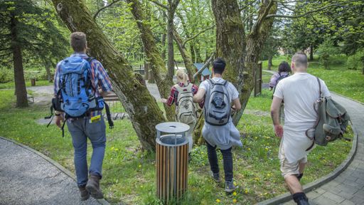A group of friends with backpacks walking in a park
