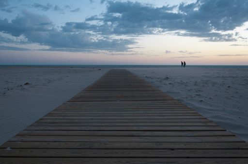 An amazing view of a wooden path in a sandy beach