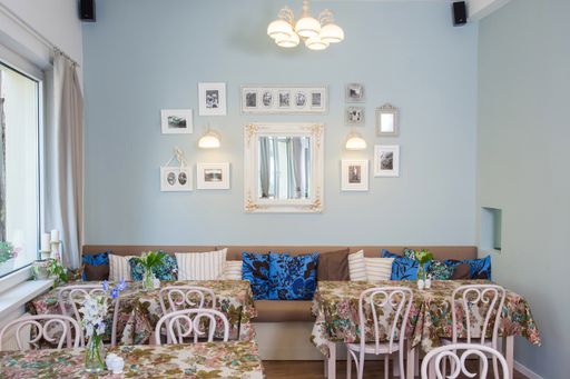 The beautiful furniture and pillows inside a neat room with nice frames and a mirror on the wall