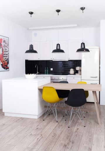 A vertical shot of a neat kitchen with modern furniture and a wooden floor