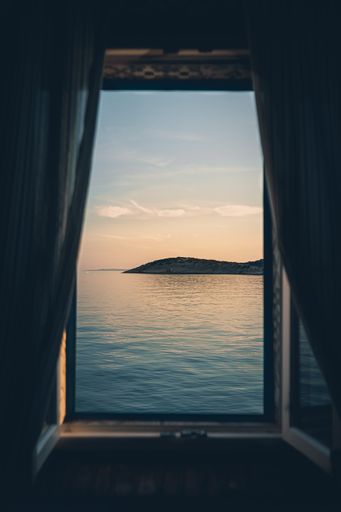 A vertical shot of the beach sunset through the window.  Cres, Croatia