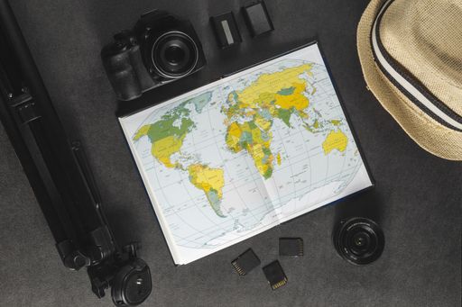 A top view of map, hat and set of photography equipment