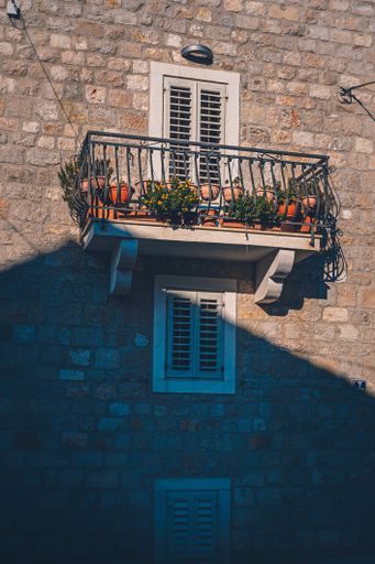 A vertical shot of a balcony with a lot of plants