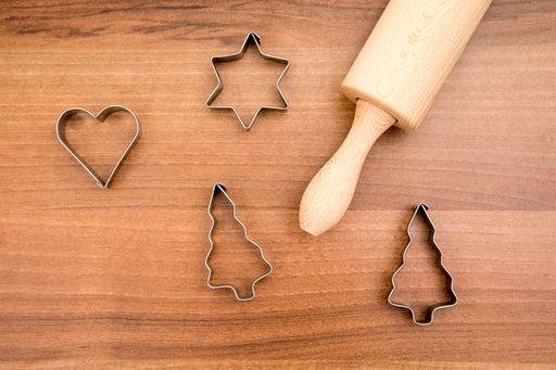 A top view of the Christmas shape cutters and the rolling pin on the wooden background