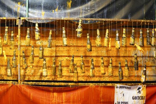 Carnival shooting arcade game with bottles and gun.